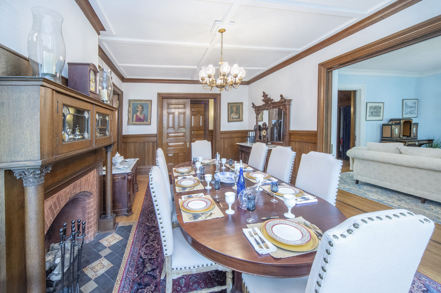 The formal dining room with a carved fireplace and stained glass