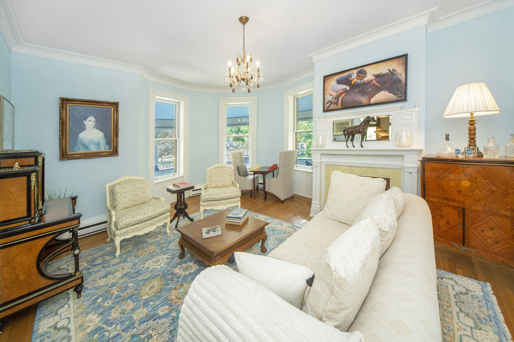 The front parlor with a marble fireplace and equestrian painting